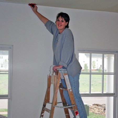 Lynnette painting the living room walls in the new house.