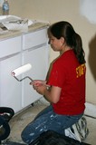 Alex painting the kitchen cabinets, after they had been cleaned and sanded -- from all the smoke and soot damage.