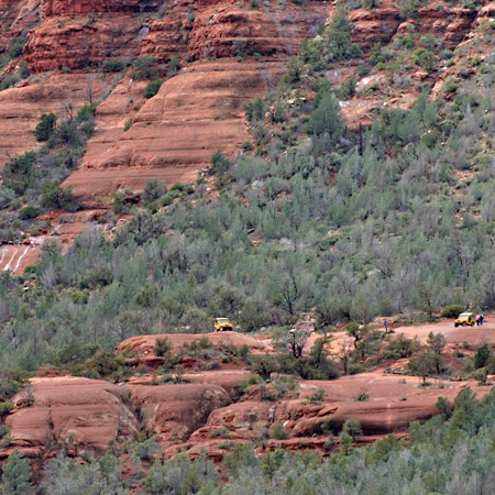 Jeeps riding on the rocks in the distance.