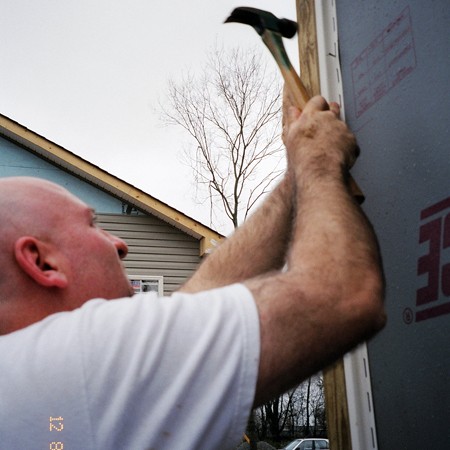 Jim nailing up siding strips on a Habitat For Humanity house.