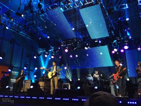 John Mayer performing with band on TV. 