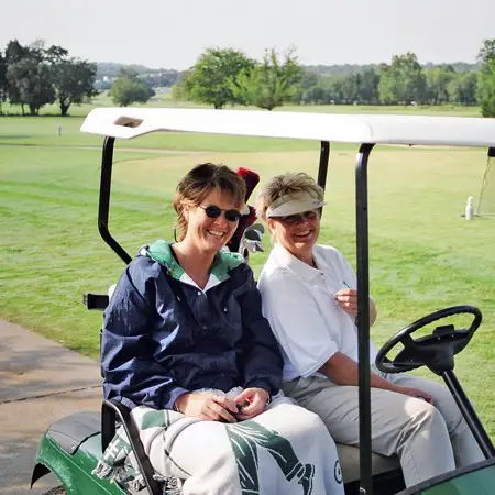 Kay and Lynnette riding in the golf cart on a chilly morning.
