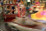 A mom and kids on a kiddie ride at the Williamson County Fair in Franklin, Tennessee.