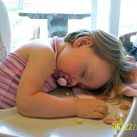 Shelby fell asleep in her high chair.