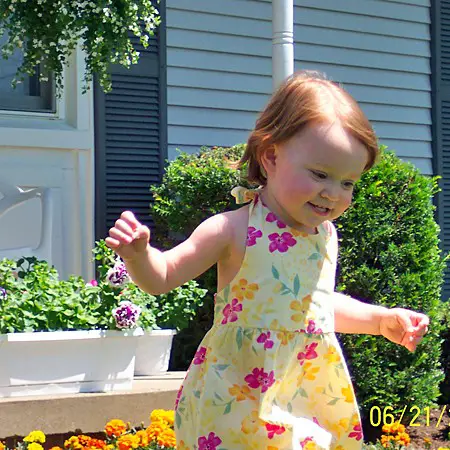Shelby skipping outside among the flowers.