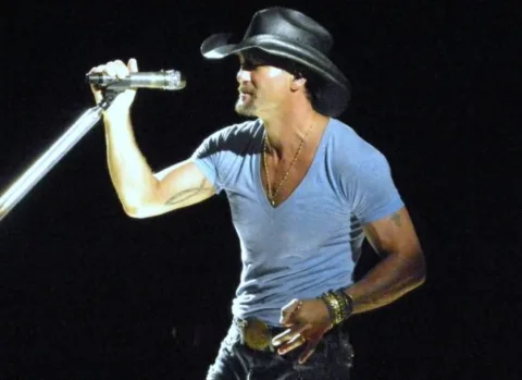 Tim McGraw singing at the microphone. 